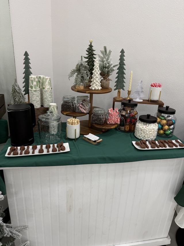 Hot cocoa station with mini trees and treats on the dessert cart