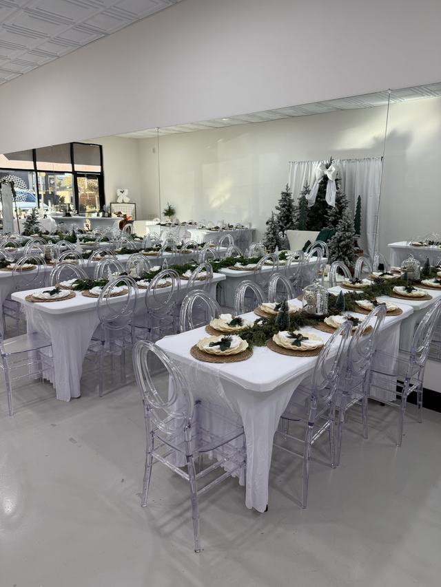 Wide view of the studio set for a holiday party with greenery runners and frosted trees